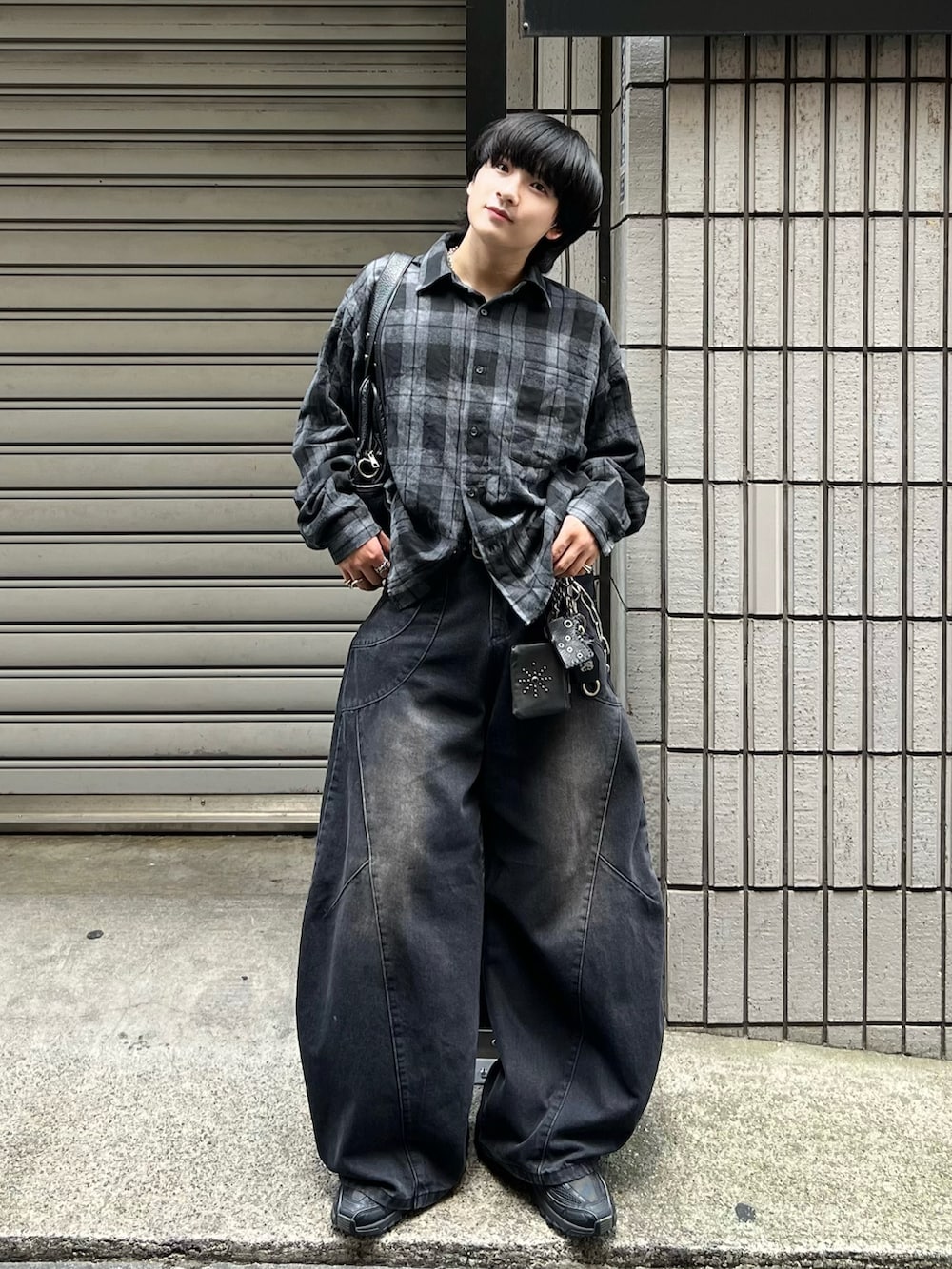 ブラック系のデニムパンツ、ブラック系のシャツ/ブラウス、ブラック系のスニーカーを着用したメンズの秋コーディネートの2枚目の写真