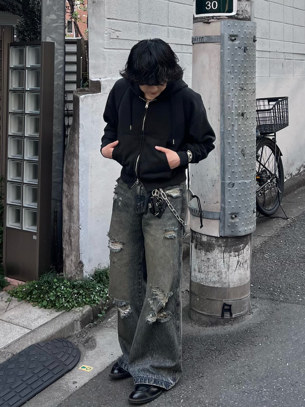 ブルー系のデニムパンツ、ブラック系のパーカー、ブラック系のドレスシューズを着用したメンズの春コーディネートの3枚目の写真