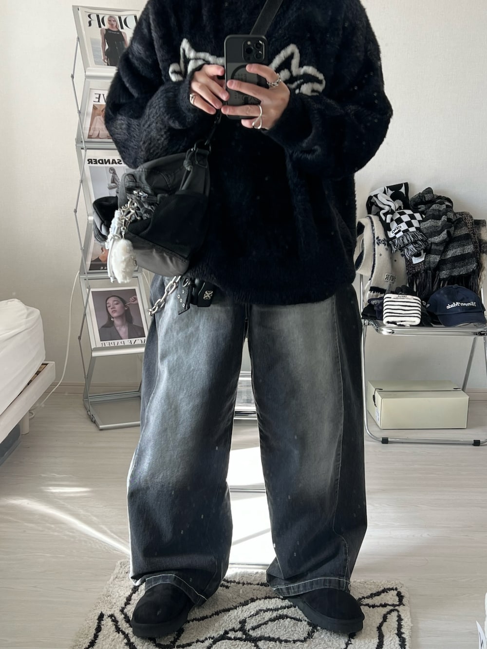 ブラック系のデニムパンツ、ブラック系のスリッポン、グレー系のショルダーバッグを着用したメンズの冬コーディネートの2枚目の写真