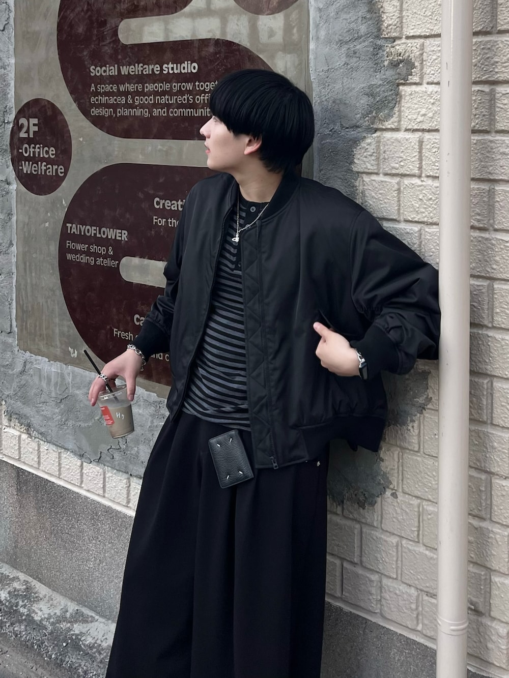 ブラック系のTシャツ/カットソー、ブラック系のスラックス、ブラック系のMA-1を着用したメンズの冬コーディネートの2枚目の写真