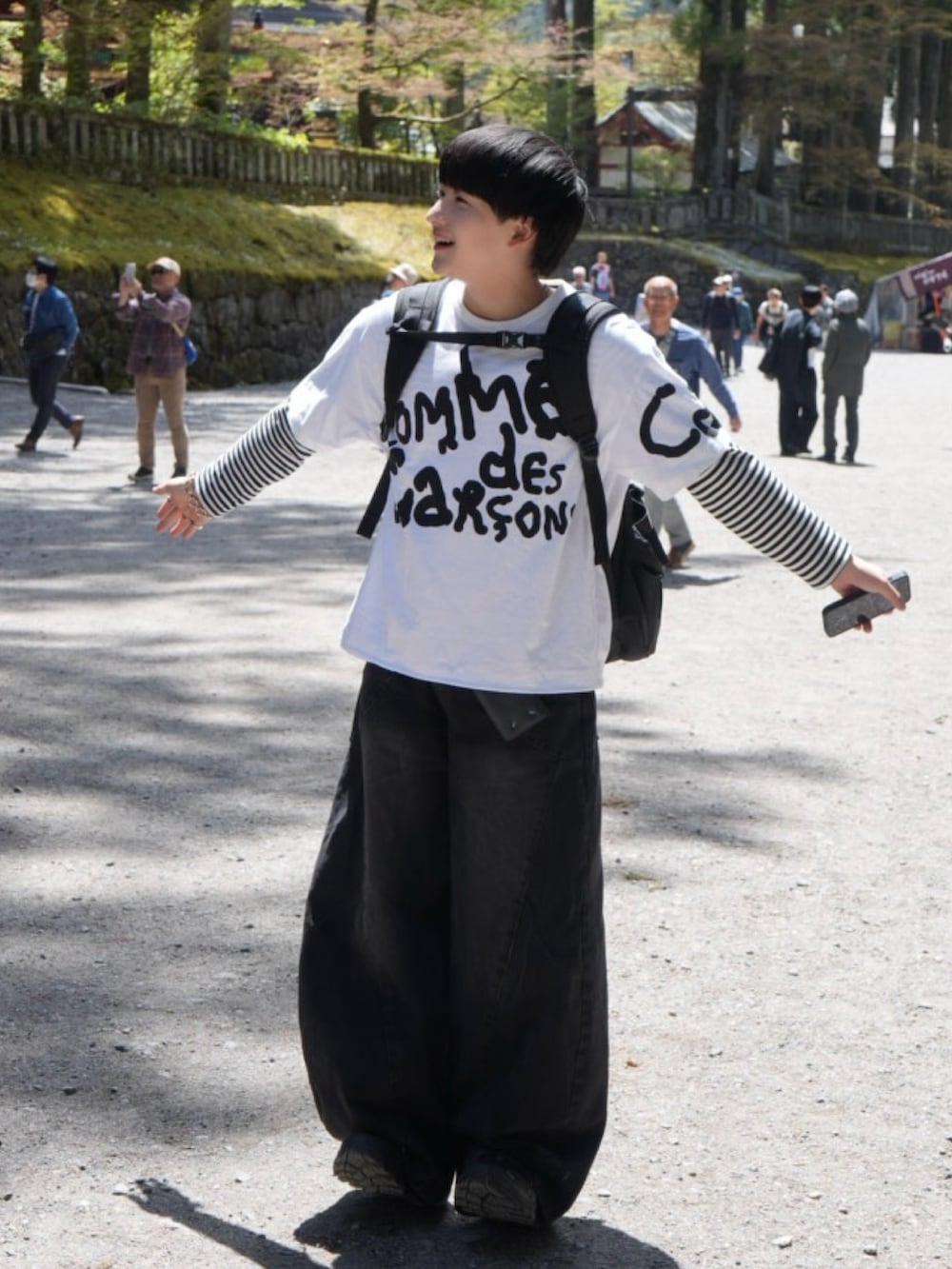 ブラック系のデニムパンツ、ブラック系のTシャツ/カットソー、ブラック系のスニーカーを着用したメンズの春コーディネートの2枚目の写真