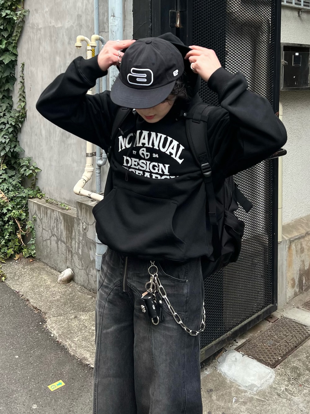 ブラック系のパーカー、ブラック系のデニムパンツ、ブラック系のスニーカーを着用したメンズの春コーディネートの2枚目の写真