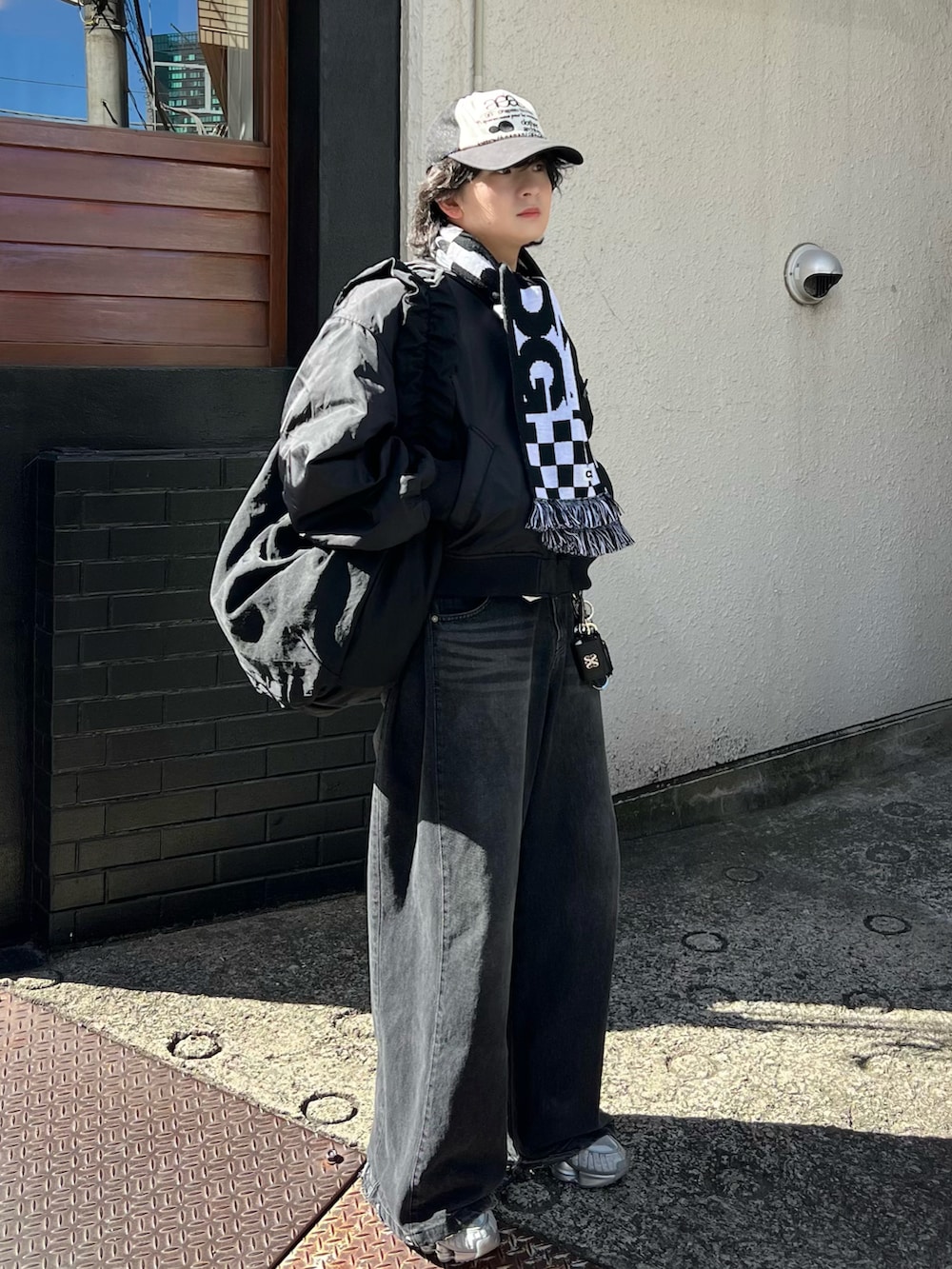 ブラック系のショルダーバッグ、グレー系のデニムパンツ、ブラック系のMA-1を着用したメンズの冬コーディネートの2枚目の写真