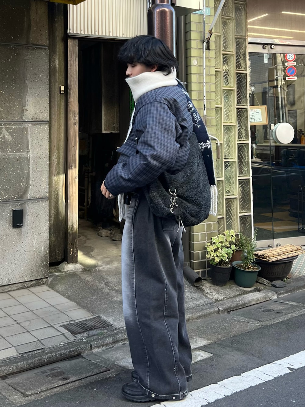 ブルー系のブルゾン、ブラック系のデニムパンツ、ブラック系のスニーカーを着用したメンズの冬コーディネートの2枚目の写真