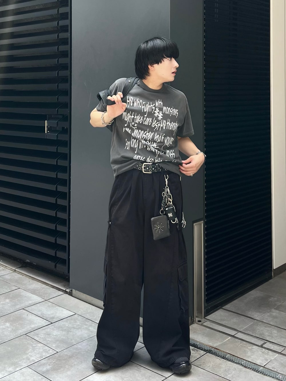 ブラック系のカーゴパンツ、グレー系のTシャツ/カットソー、ブラック系のショルダーバッグを着用したメンズの秋コーディネートの2枚目の写真