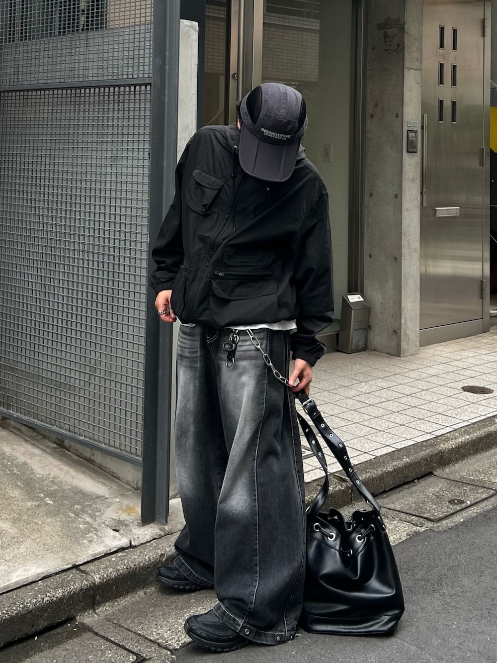 ブラック系のブルゾン、ブラック系のデニムパンツ、ブラック系のスニーカーを着用したメンズの秋コーディネートの2枚目の写真