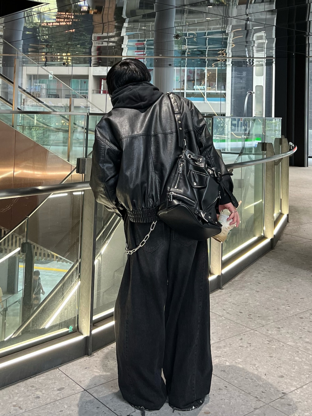 ブラック系のブルゾン、ブラック系のデニムパンツ、ブラック系のスニーカーを着用したメンズの秋コーディネートの3枚目の写真