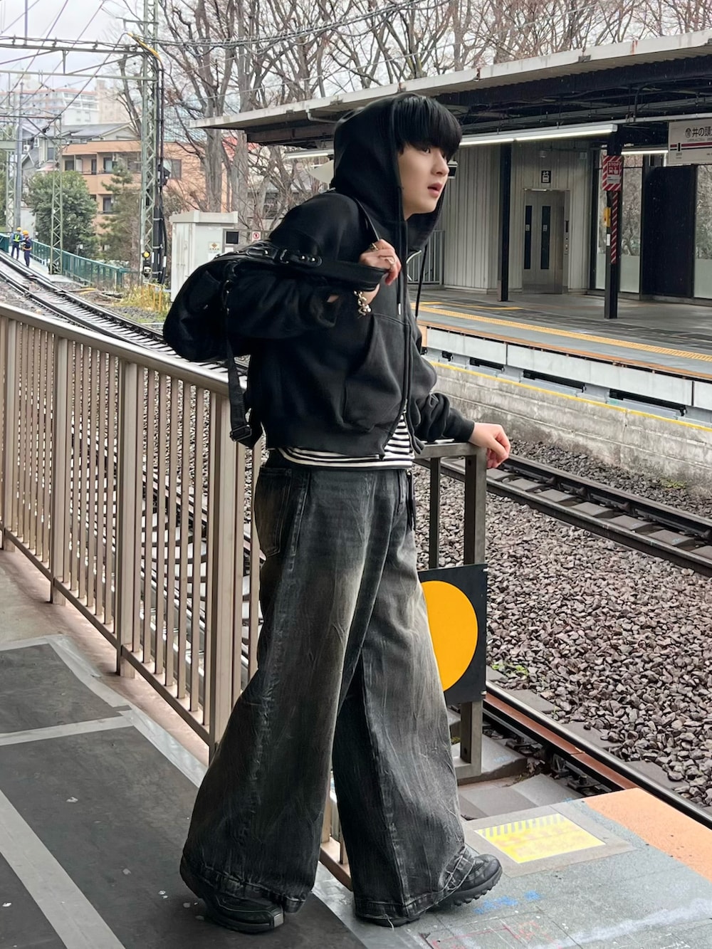 ブラック系のデニムパンツ、ブラック系のパーカー、ブラック系のTシャツ/カットソーを着用したメンズの春コーディネートの2枚目の写真