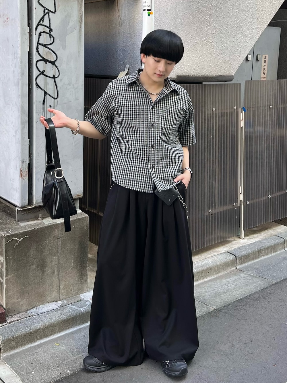 ブラック系のスラックス、ブラック系のシャツ/ブラウス、ブラック系のショルダーバッグを着用したメンズの春コーディネートの2枚目の写真