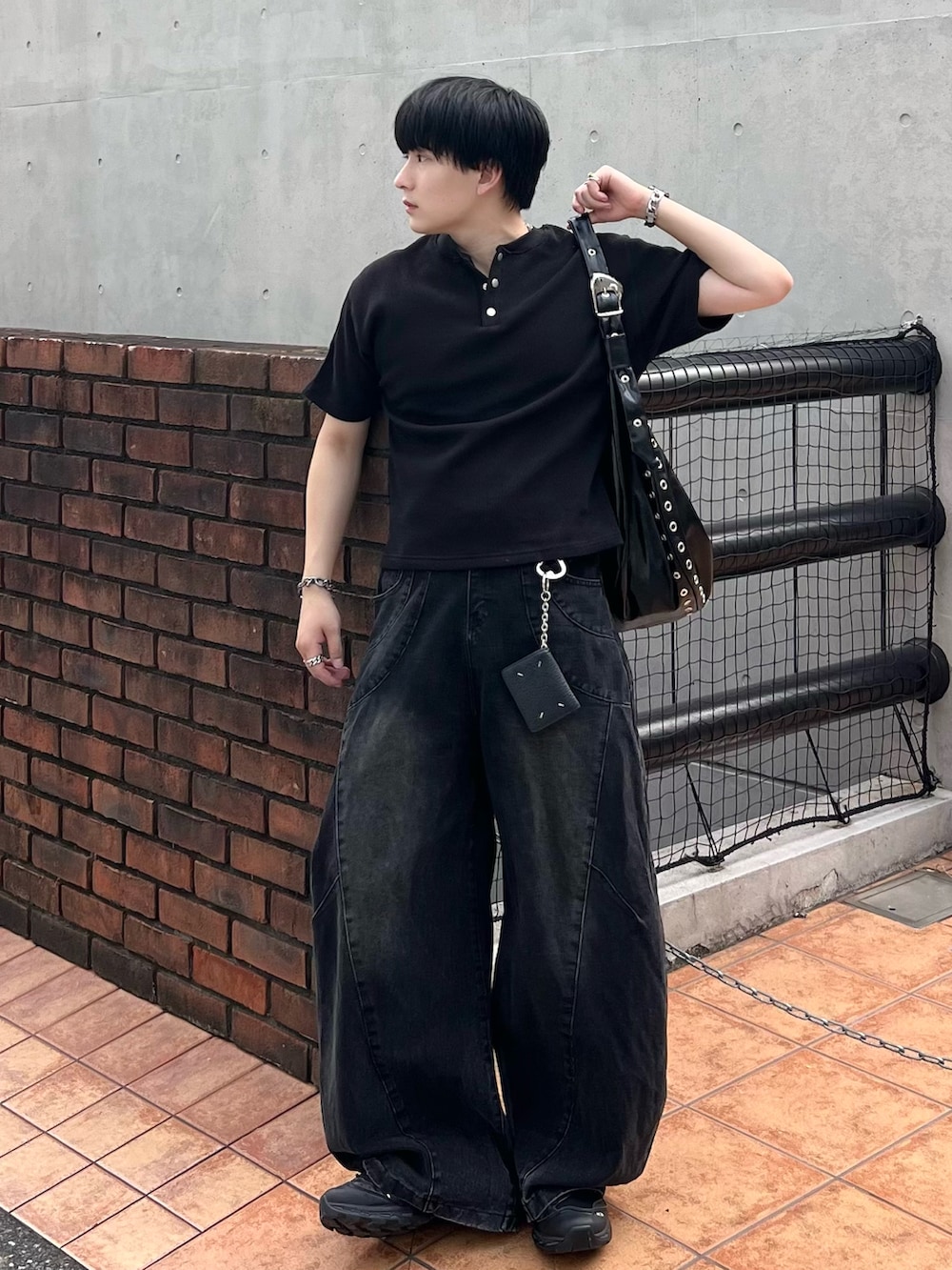 ブラック系のTシャツ/カットソー、ブラック系のデニムパンツ、ブラック系のショルダーバッグを着用したメンズの夏コーディネートの2枚目の写真