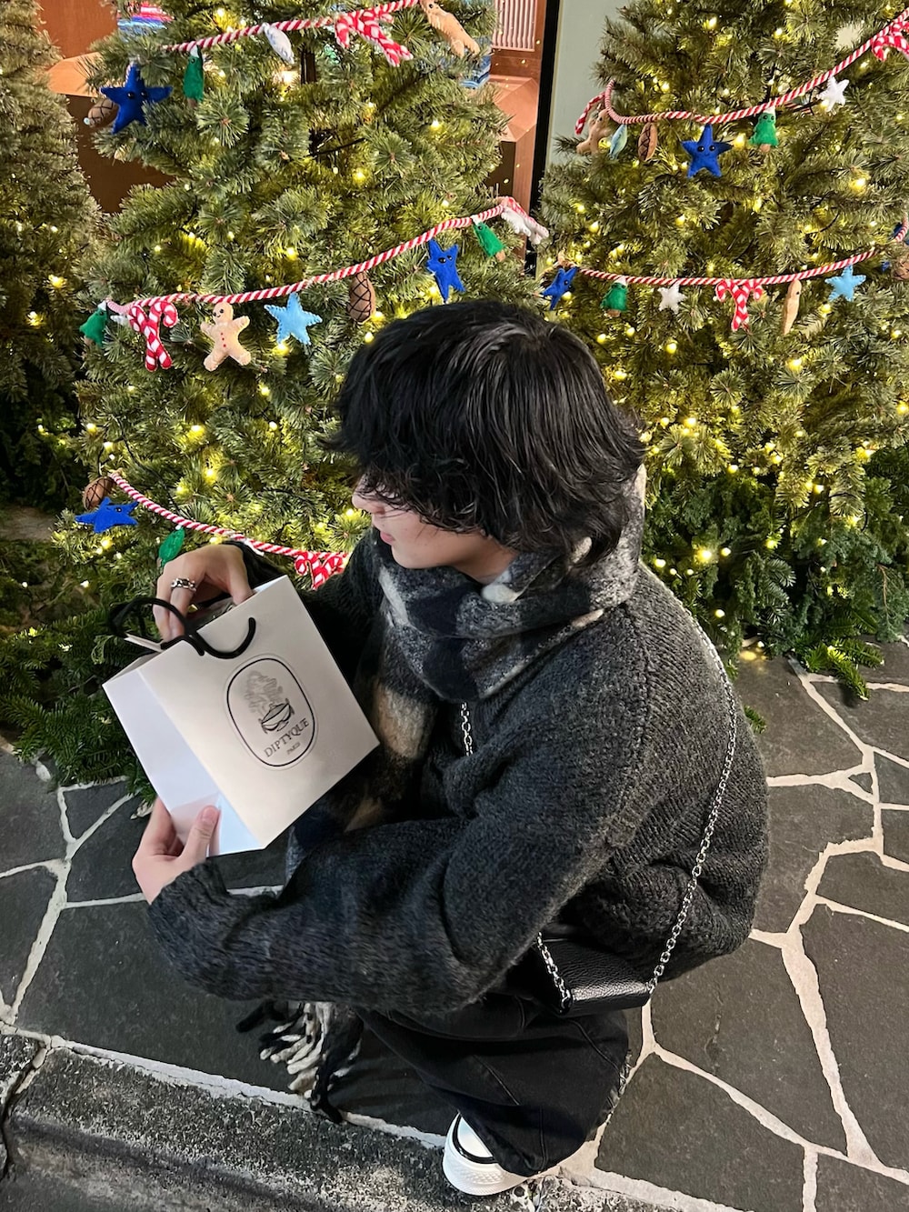 グレー系のニット/セーター、ブラック系のデニムパンツ、ブラック系のスニーカーを着用したメンズの冬コーディネートの3枚目の写真