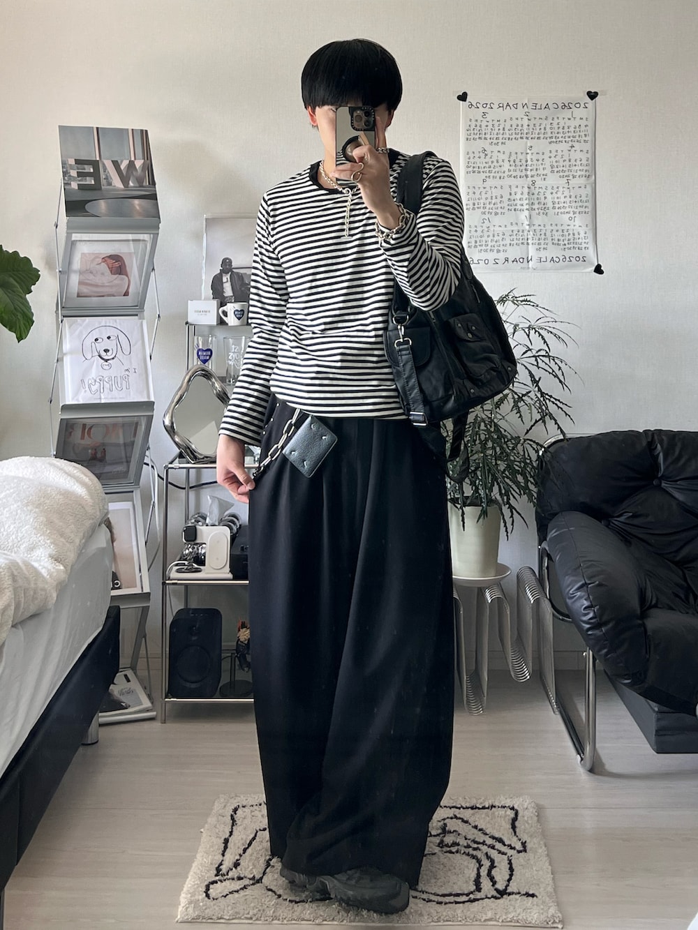 ブラック系のTシャツ/カットソー、ブラック系のスラックス、ブラック系のショルダーバッグを着用したメンズの春コーディネートの2枚目の写真