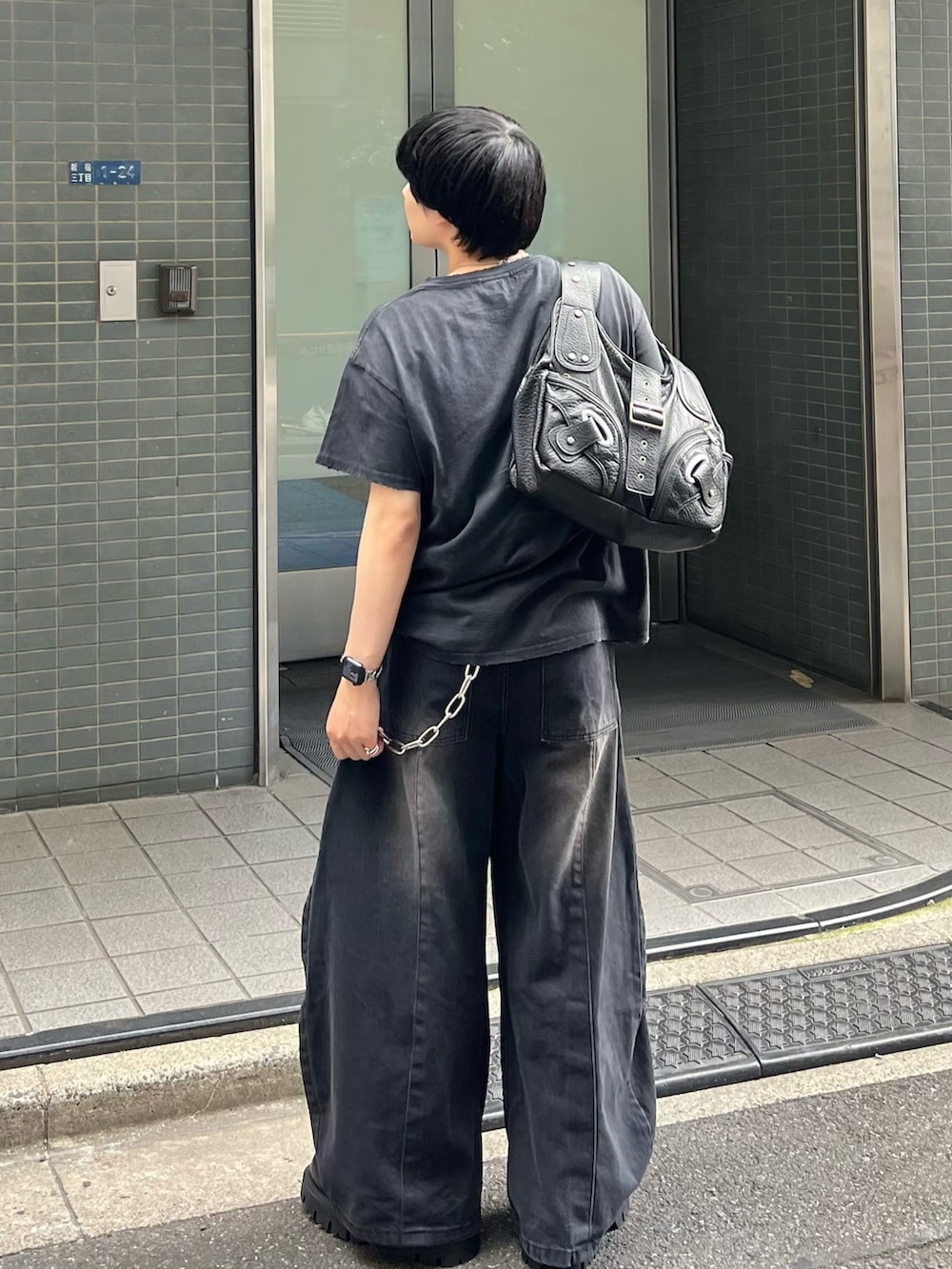 ブラック系のTシャツ/カットソー、ブラック系のデニムパンツ、ブラック系のショルダーバッグを着用したメンズの夏コーディネートの3枚目の写真