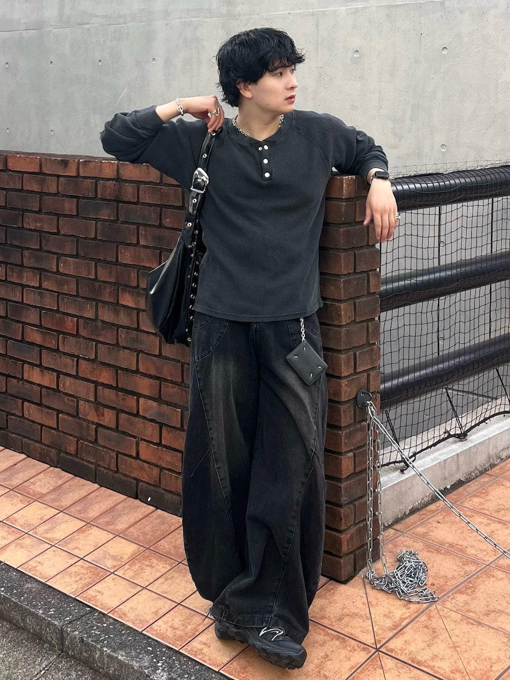 グレー系のTシャツ/カットソー、ブラック系のデニムパンツ、ブラック系のショルダーバッグを着用したメンズの秋コーディネートの2枚目の写真