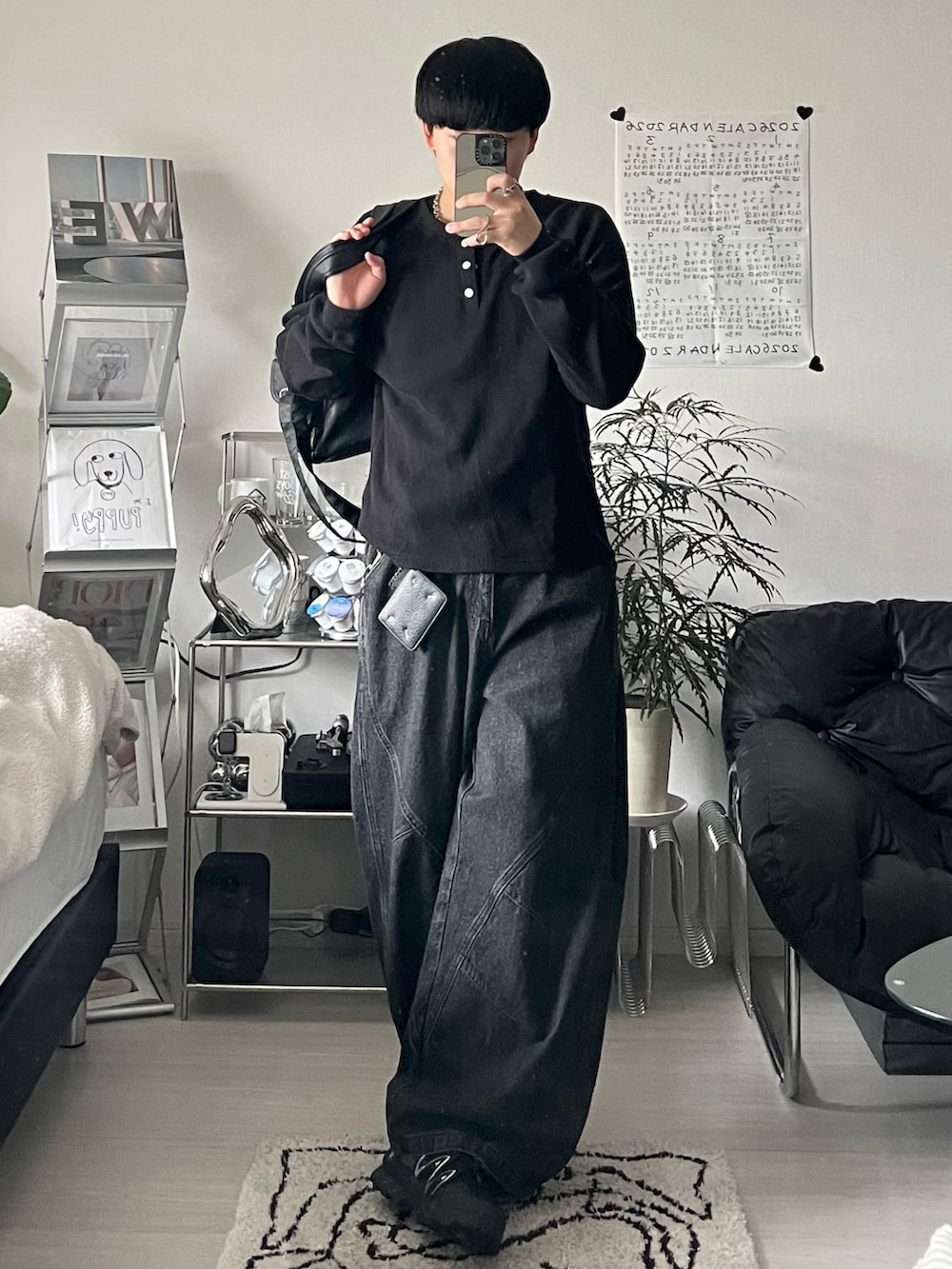 ブラック系のデニムパンツ、ブラック系のTシャツ/カットソー、ブラック系のショルダーバッグを着用したメンズの春コーディネートの2枚目の写真