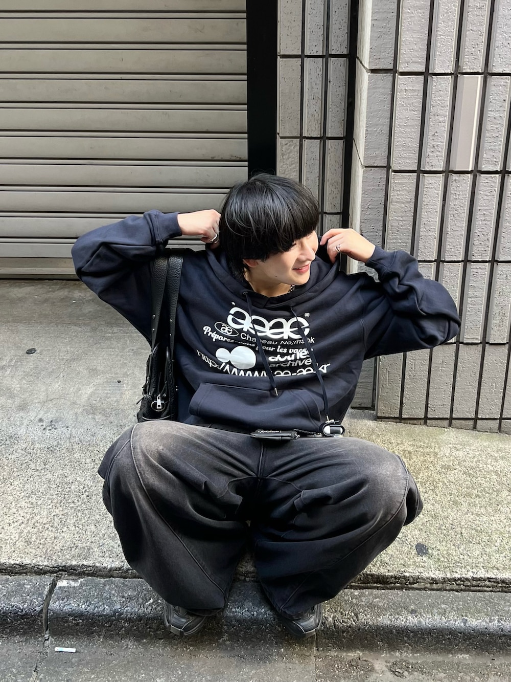 ブルー系のスウェット、ブラック系のデニムパンツ、ブラック系のスニーカーを着用したメンズの秋コーディネートの3枚目の写真