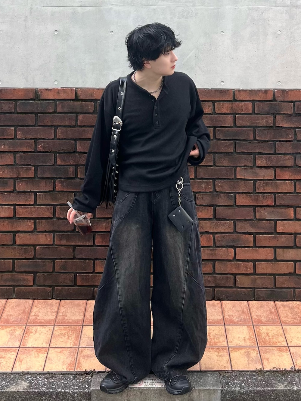 ブラック系のTシャツ/カットソー、ブラック系のデニムパンツ、ブラック系のショルダーバッグを着用したメンズの秋コーディネートの2枚目の写真
