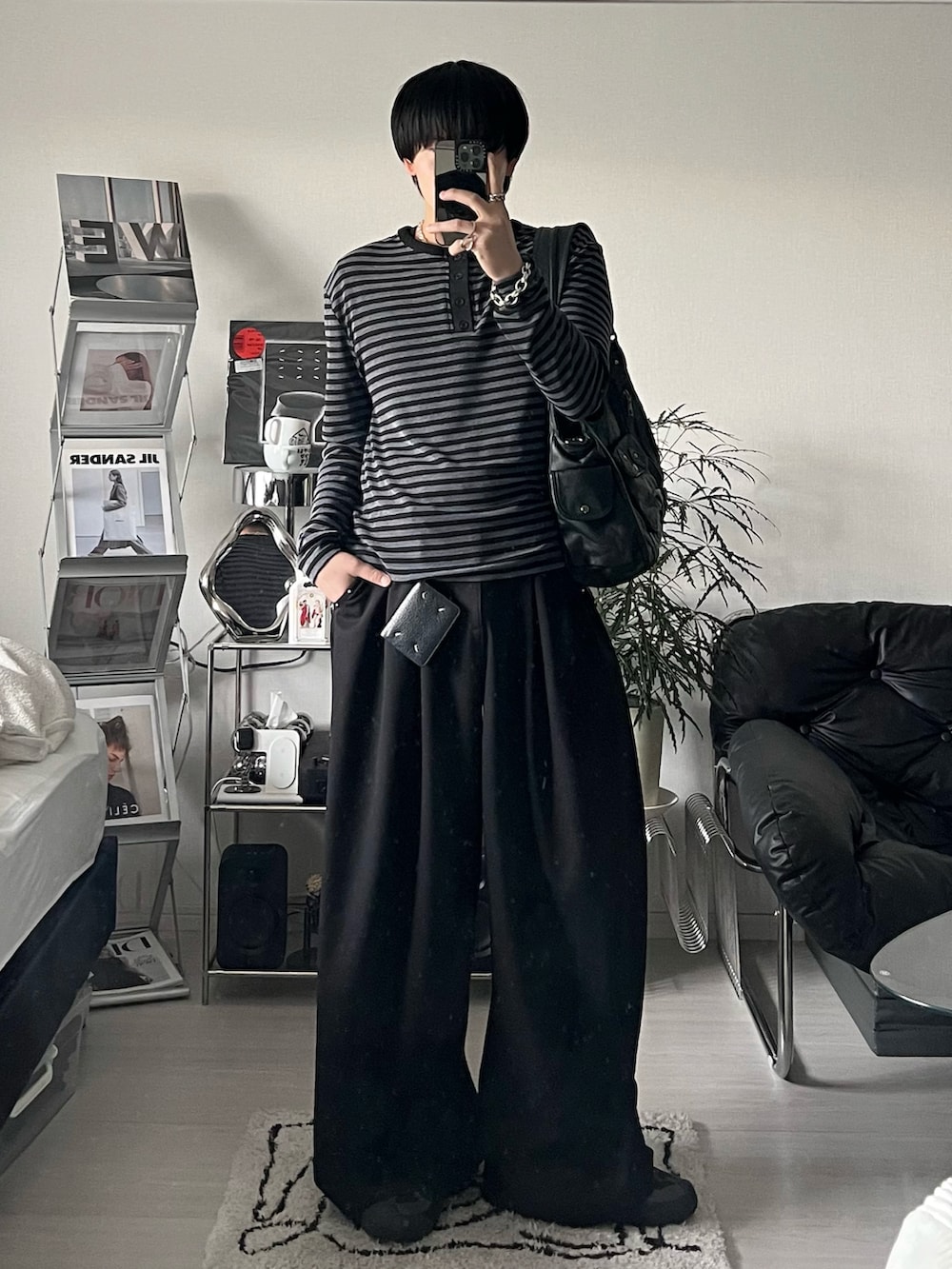 ブラック系のTシャツ/カットソー、ブラック系のスラックス、ブラック系のスニーカーを着用したメンズの冬コーディネートの2枚目の写真