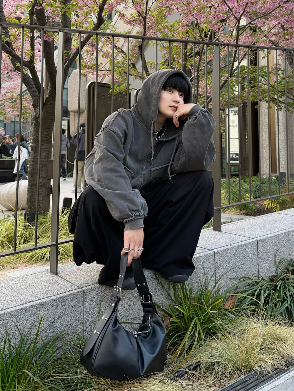 ブラック系のスラックス、ブラック系のパーカー、ブラック系のTシャツ/カットソーを着用したメンズの春コーディネートの2枚目の写真