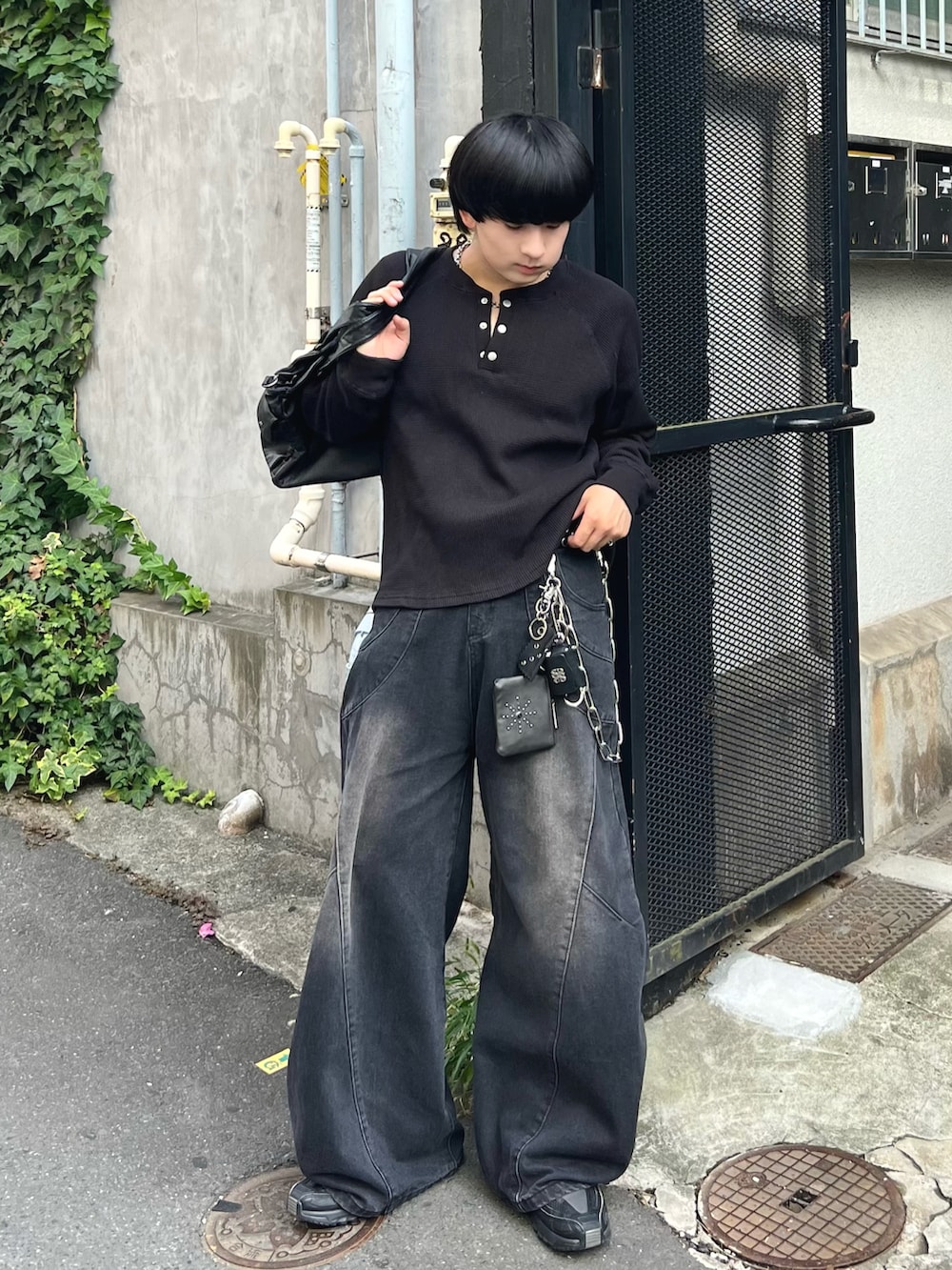 ブラック系のTシャツ/カットソー、ブラック系のデニムパンツ、ブラック系のショルダーバッグを着用したメンズの秋コーディネートの3枚目の写真