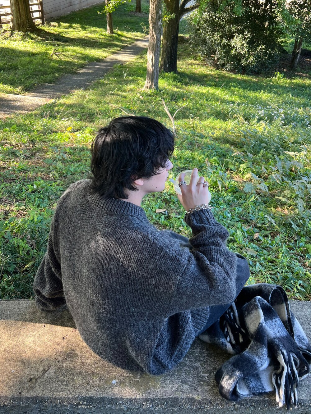 グレー系のニット/セーター、ブラック系のデニムパンツ、ブラック系のブーツを着用したメンズの冬コーディネートの3枚目の写真