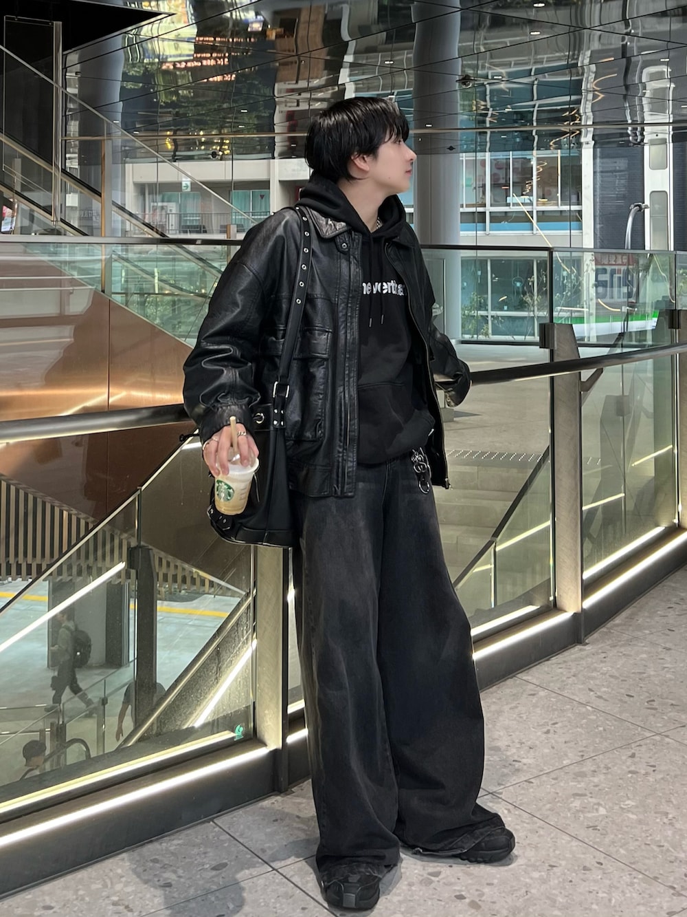 ブラック系のブルゾン、ブラック系のデニムパンツ、ブラック系のスニーカーを着用したメンズの秋コーディネートの2枚目の写真