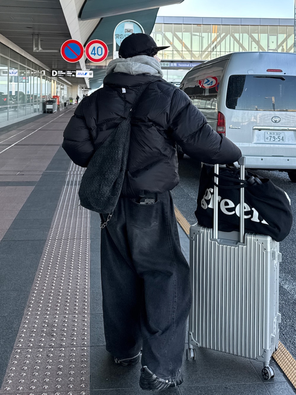 ブラック系のダウンジャケット/コート、グレー系のデニムパンツ、ブラック系のスニーカーを着用したメンズの冬コーディネートの3枚目の写真