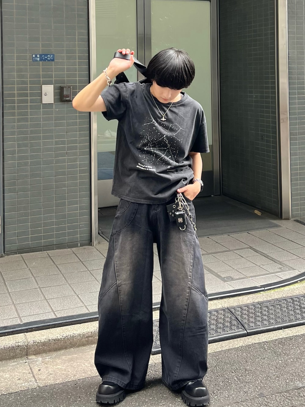 ブラック系のTシャツ/カットソー、ブラック系のデニムパンツ、ブラック系のショルダーバッグを着用したメンズの夏コーディネートの2枚目の写真