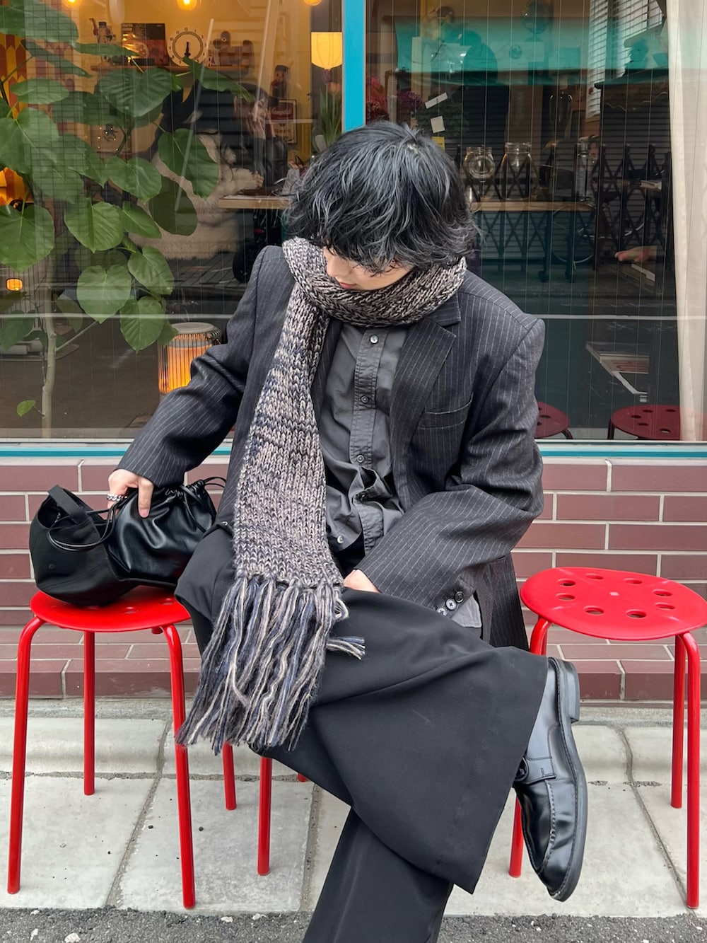 グレー系のテーラードジャケット、ブラック系のショルダーバッグ、ブラック系のドレスシューズを着用したメンズの冬コーディネートの2枚目の写真