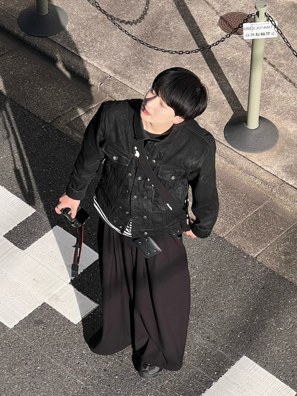 ブラック系のデニムジャケット、ブラック系のTシャツ/カットソー、ブラック系のスラックスを着用したメンズの春コーディネートの2枚目の写真