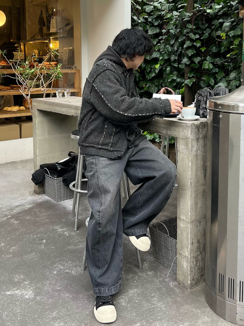 グレー系のカーディガン/ボレロ、ブラック系のパーカー、ブラック系のデニムパンツを着用したメンズの冬コーディネートの3枚目の写真