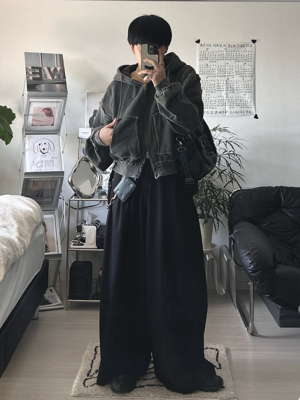 ブラック系のパーカー、ブラック系のスラックス、ブラック系のショルダーバッグを着用したメンズの春コーディネートの2枚目の写真