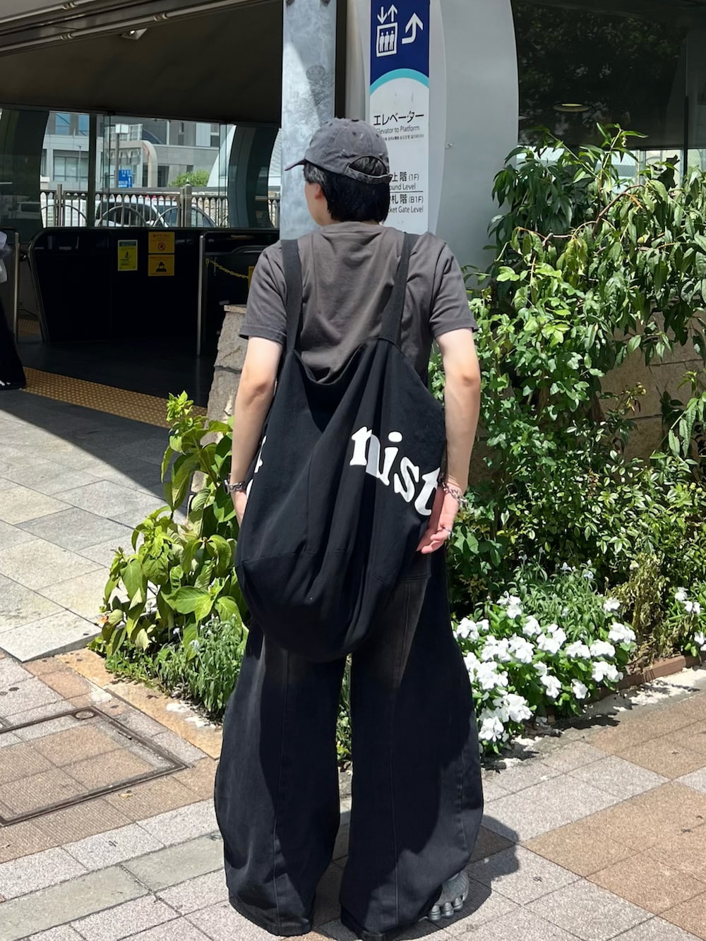 ブラック系のデニムパンツ、グレー系のTシャツ/カットソー、シルバー系のスニーカーを着用したメンズの夏コーディネートの3枚目の写真