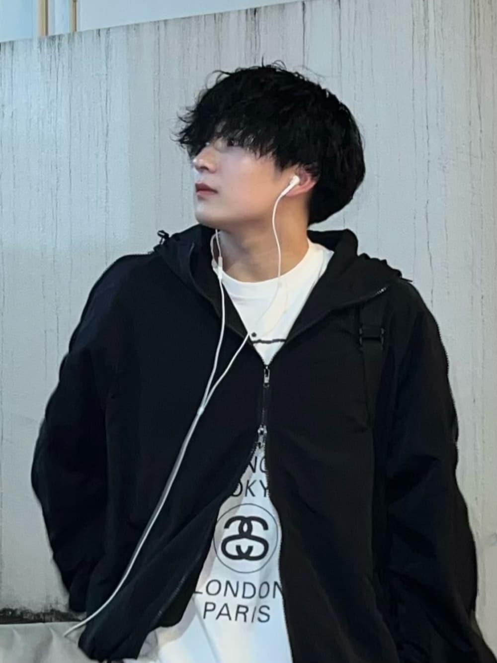 ブラック系のデニムパンツ、ブラック系のスニーカー、ホワイト系のTシャツ/カットソーを着用したメンズの秋コーディネートの2枚目の写真