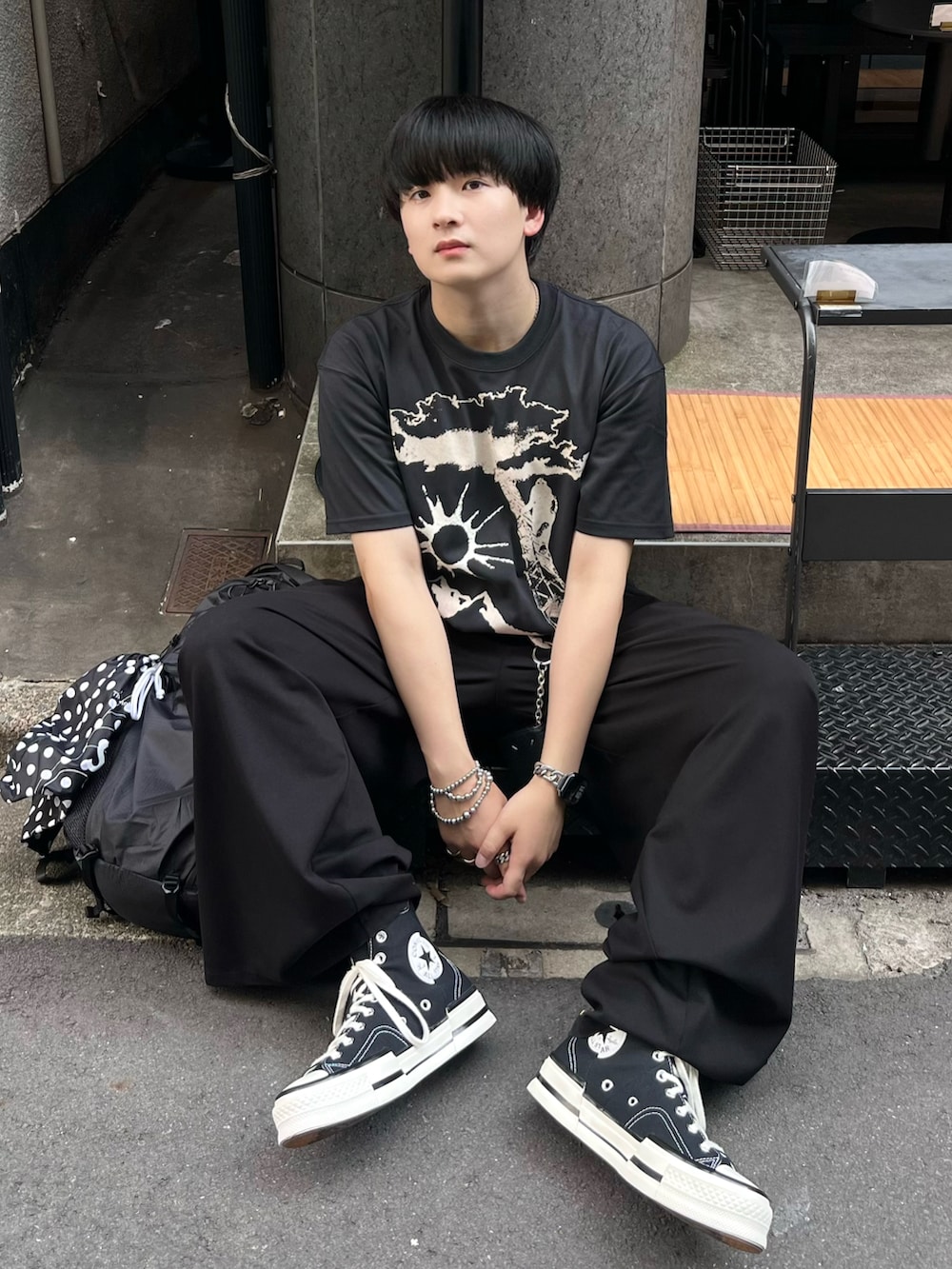 ブラック系のTシャツ/カットソー、ブラック系のスラックス、その他のバックパック/リュックを着用したメンズの夏コーディネートの2枚目の写真