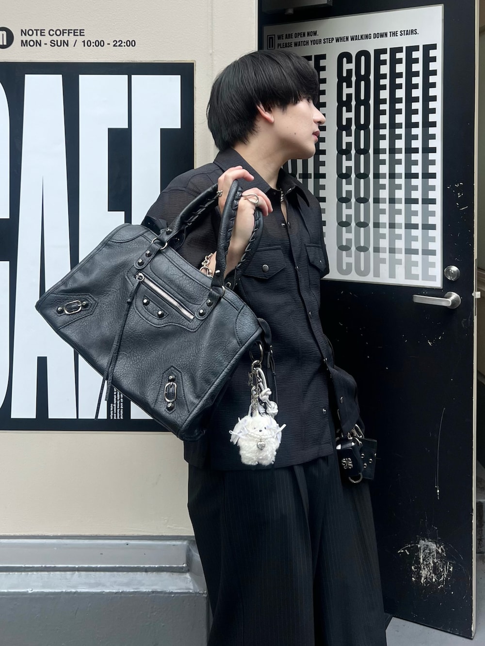 ブラック系のボストンバッグ、ブラック系のシャツ/ブラウス、ブラック系のスラックスを着用したメンズの夏コーディネートの2枚目の写真