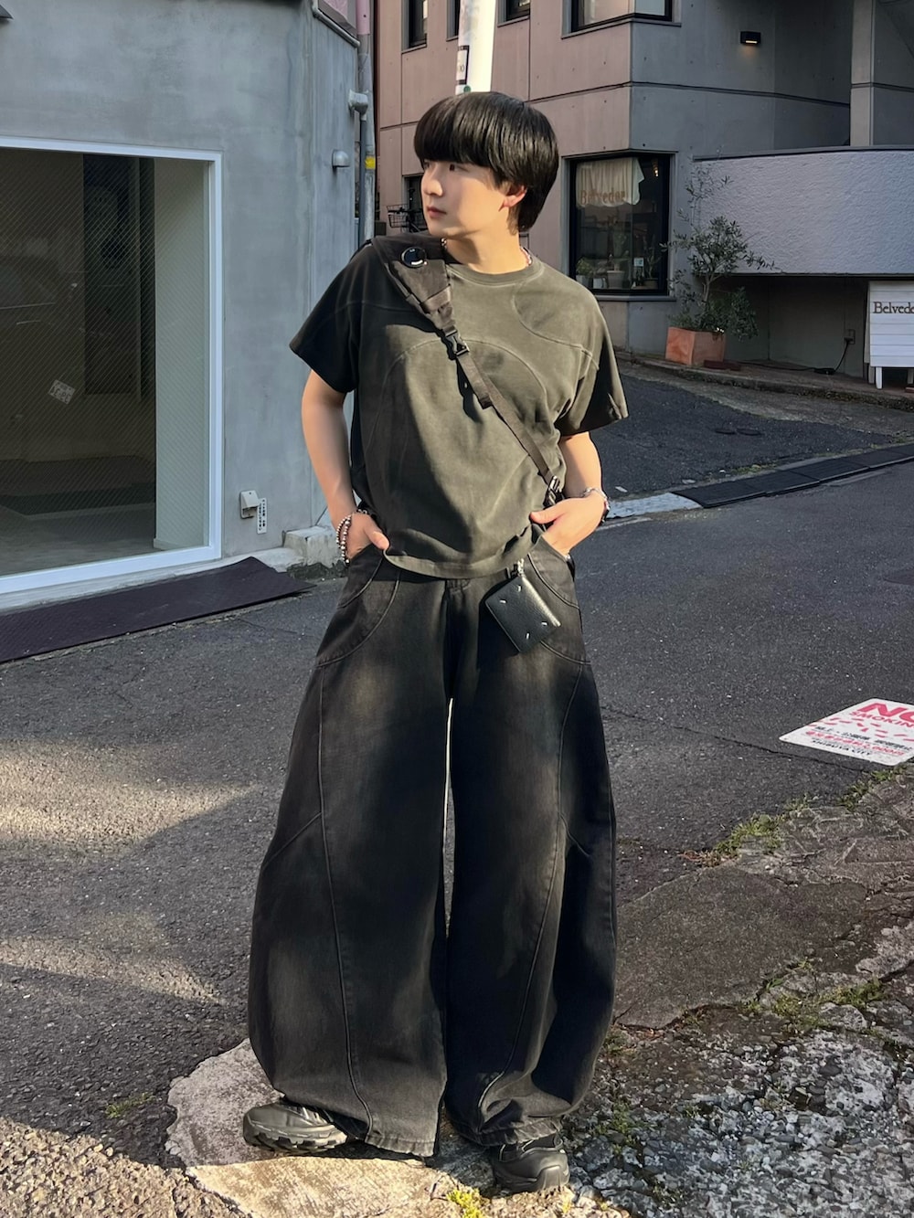 ブラック系のTシャツ/カットソー、ブラック系のデニムパンツ、ブラック系のスニーカーを着用したメンズの夏コーディネートの2枚目の写真