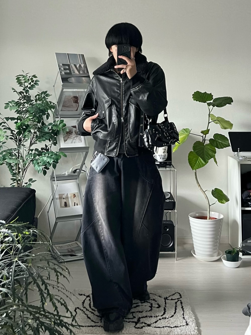 ブラック系のデニムパンツ、ブラック系のショルダーバッグ、ブラック系のブルゾンを着用したメンズの秋コーディネートの2枚目の写真