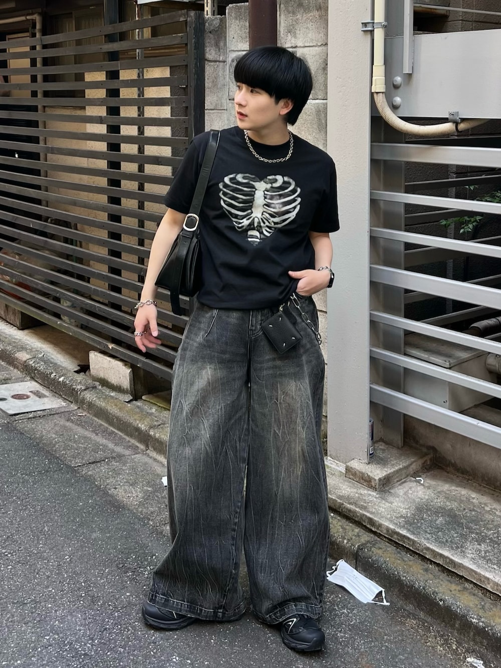 ブラック系のTシャツ/カットソー、ブラック系のデニムパンツ、ブラック系のショルダーバッグを着用したメンズの春コーディネートの2枚目の写真