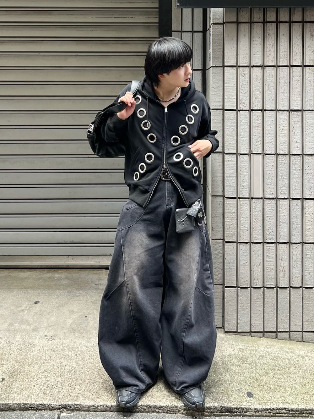 ブラック系のデニムパンツ、ブラック系のパーカー、グレー系のタンクトップを着用したメンズの秋コーディネートの3枚目の写真