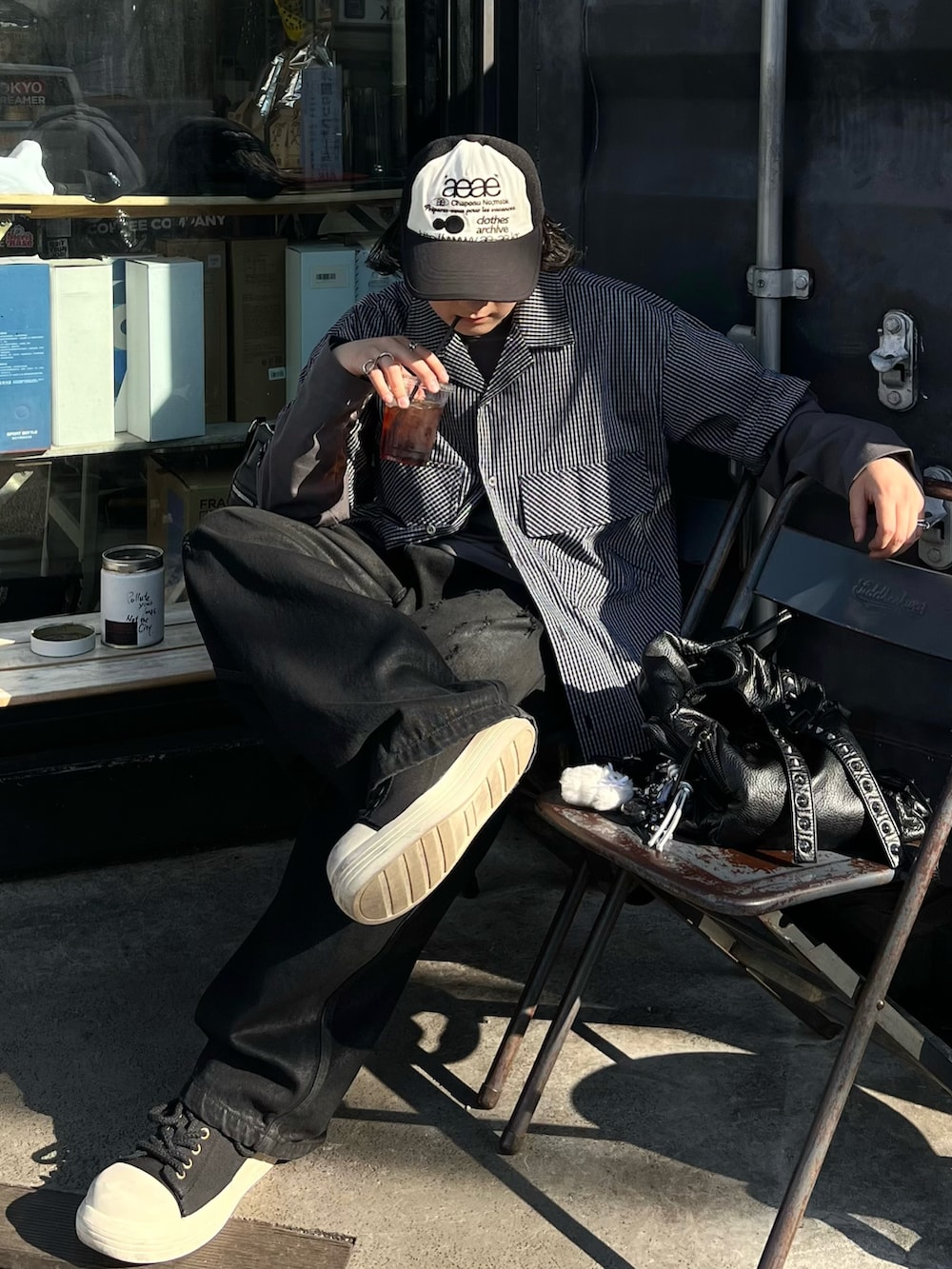 ブラック系のシャツ/ブラウス、グレー系のTシャツ/カットソー、ブラック系のデニムパンツを着用したメンズの春コーディネートの2枚目の写真