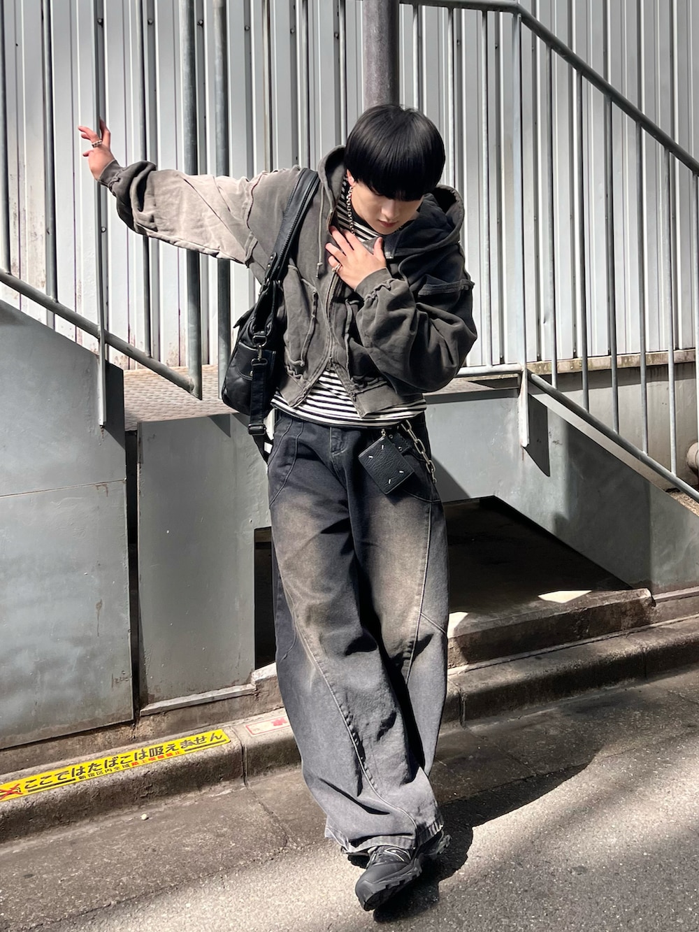 ブラック系のパーカー、ブラック系のTシャツ/カットソー、ブラック系のデニムパンツを着用したメンズの春コーディネートの2枚目の写真