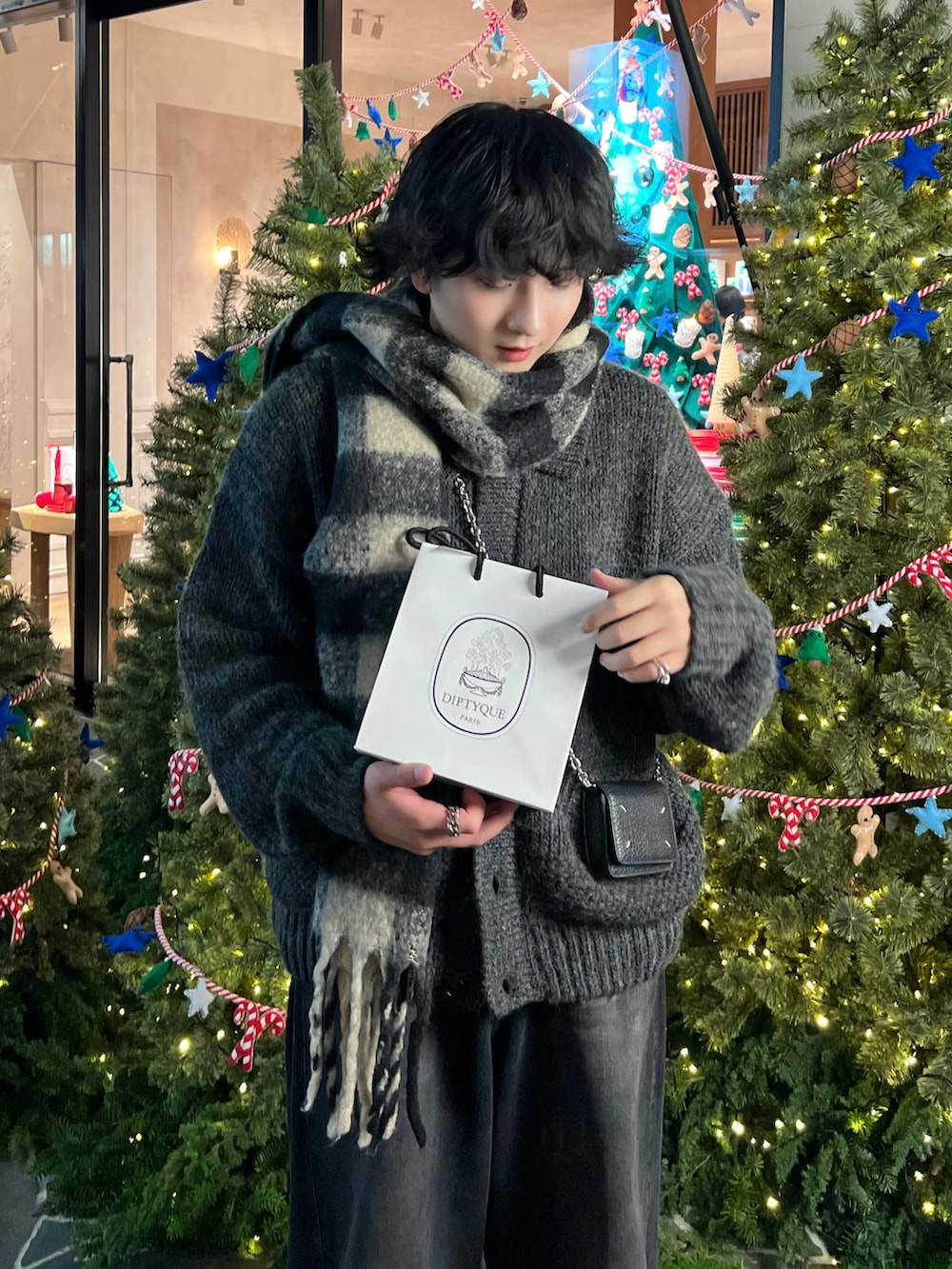 グレー系のニット/セーター、ブラック系のデニムパンツ、ブラック系のスニーカーを着用したメンズの冬コーディネートの2枚目の写真