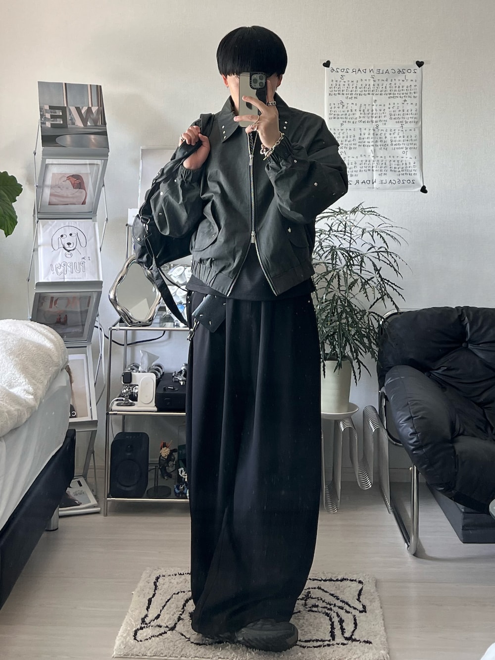 ブラック系のブルゾン、ブラック系のTシャツ/カットソー、ブラック系のスラックスを着用したメンズの春コーディネートの2枚目の写真