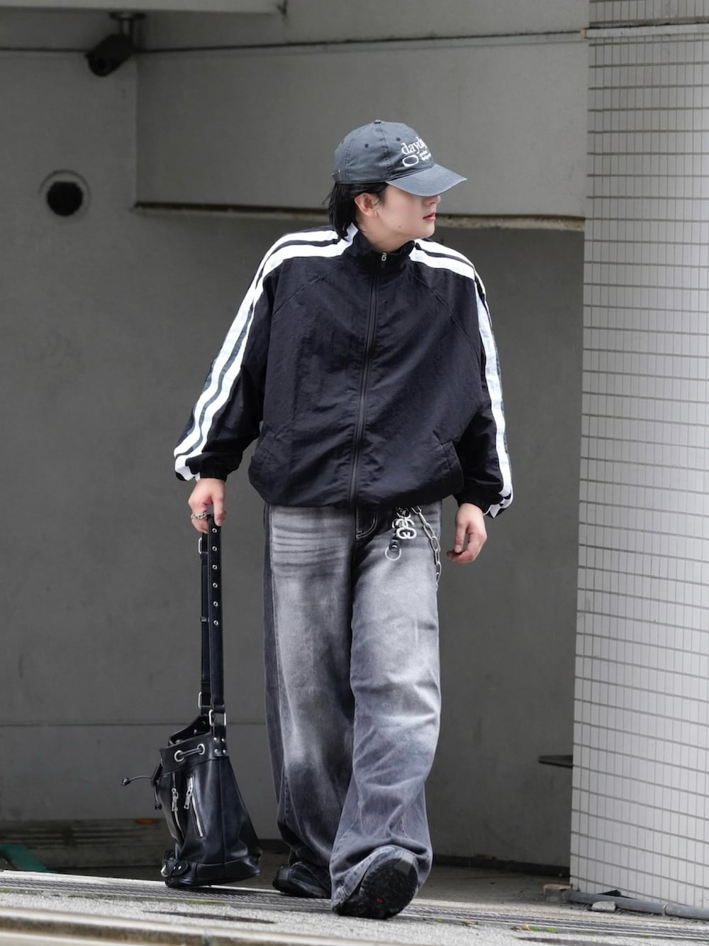 ブラック系のブルゾン、ブラック系のショルダーバッグ、ブラック系のスニーカーを着用したメンズの秋コーディネートの2枚目の写真