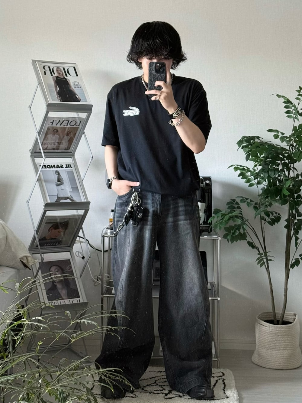 ブラック系のデニムパンツ、ブラック系のTシャツ/カットソー、ブラック系のスニーカーを着用したメンズの春コーディネートの2枚目の写真