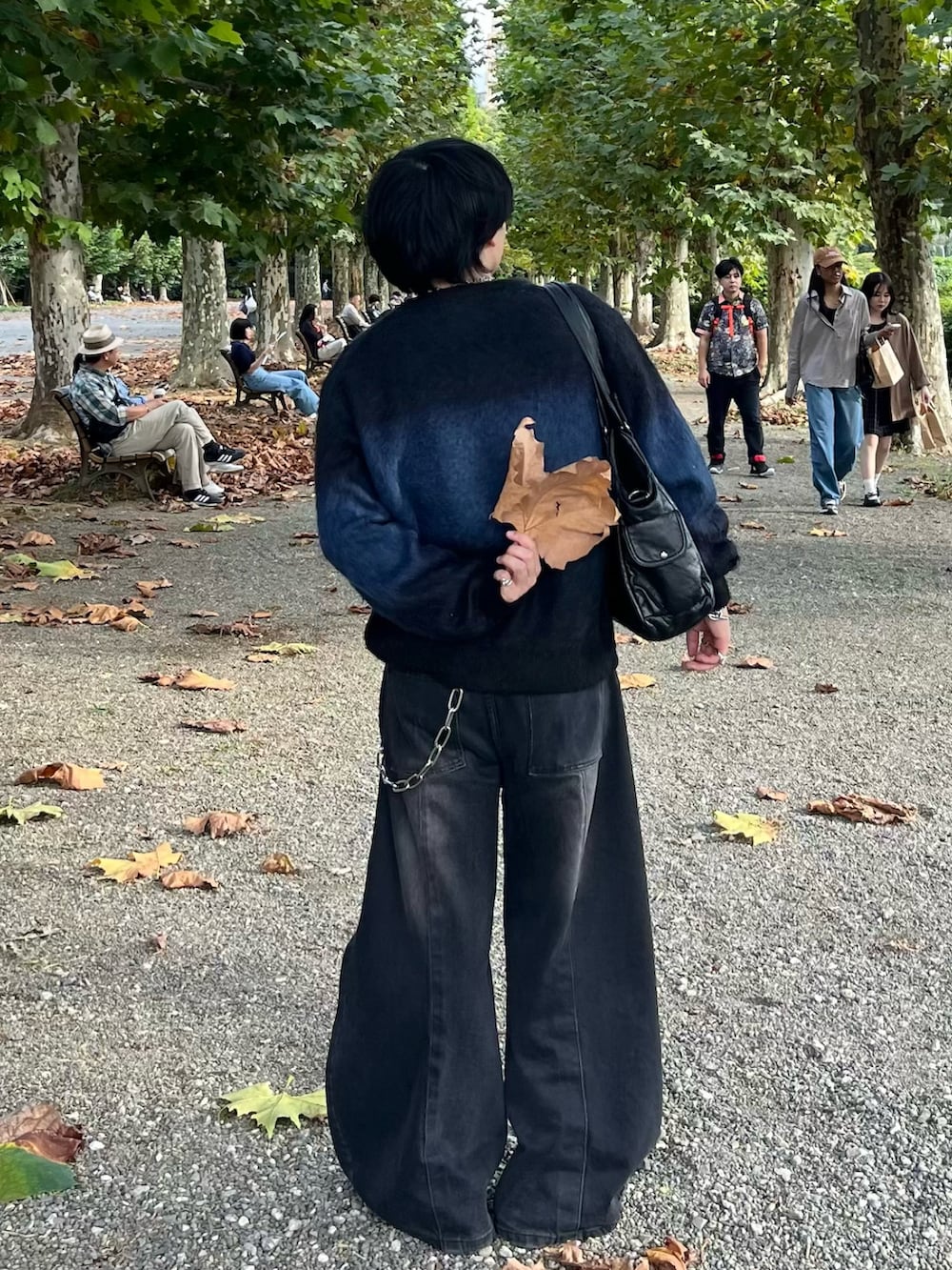 ブラック系のニット/セーター、ブラック系のデニムパンツ、ブラック系のショルダーバッグを着用したメンズの秋コーディネートの3枚目の写真