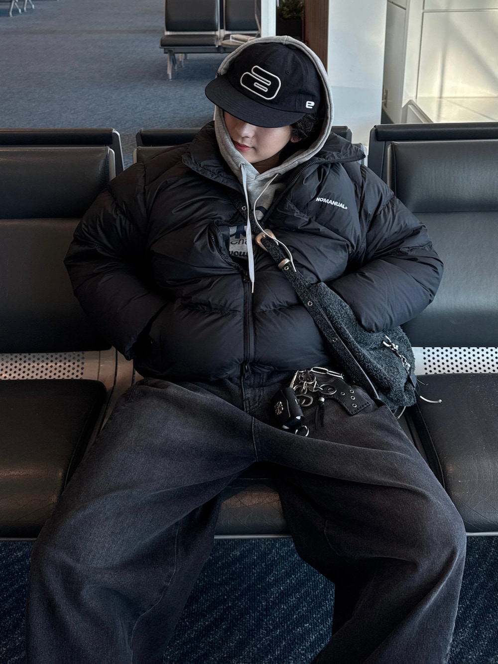 ブラック系のダウンジャケット/コート、グレー系のデニムパンツ、ブラック系のスニーカーを着用したメンズの冬コーディネートの2枚目の写真