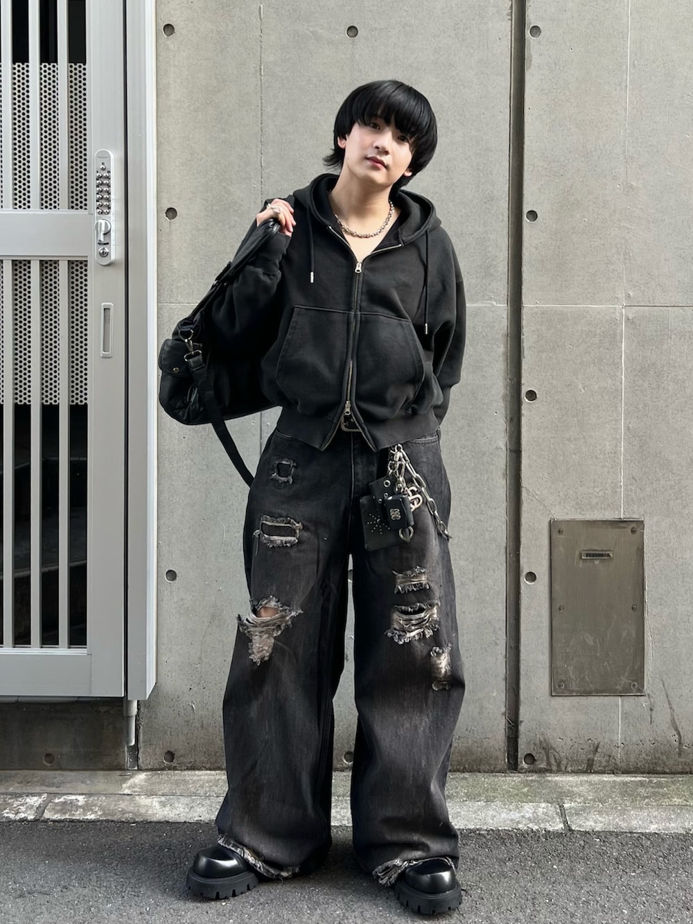 ブラック系のパーカー、ブラック系のデニムパンツ、ブラック系のショルダーバッグを着用したメンズの秋コーディネートの2枚目の写真