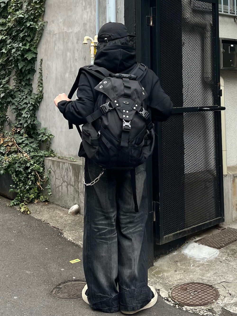 ブラック系のパーカー、ブラック系のデニムパンツ、ブラック系のスニーカーを着用したメンズの春コーディネートの4枚目の写真